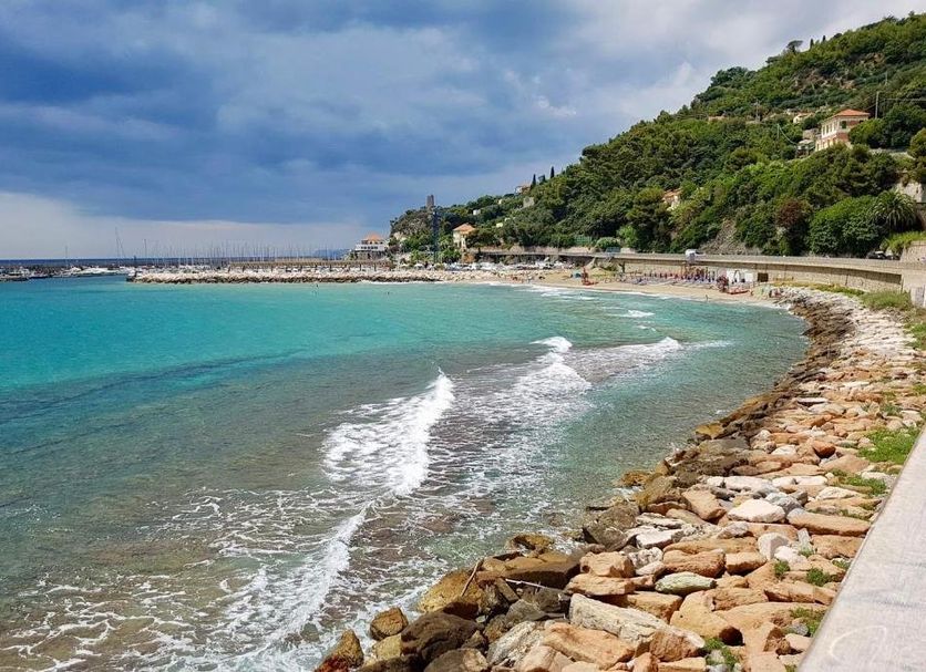 Hotel Del Golfo in Finale Ligure overlooking a turquoise bay, rocky shoreline, and hillside coast
