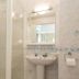 The Glendeveor Newquay bathroom with shower enclosure, pedestal sink and mirror