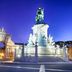 Pousada de Lisboa in Lisbon with view of a lit equestrian monument and grand arch at dusk