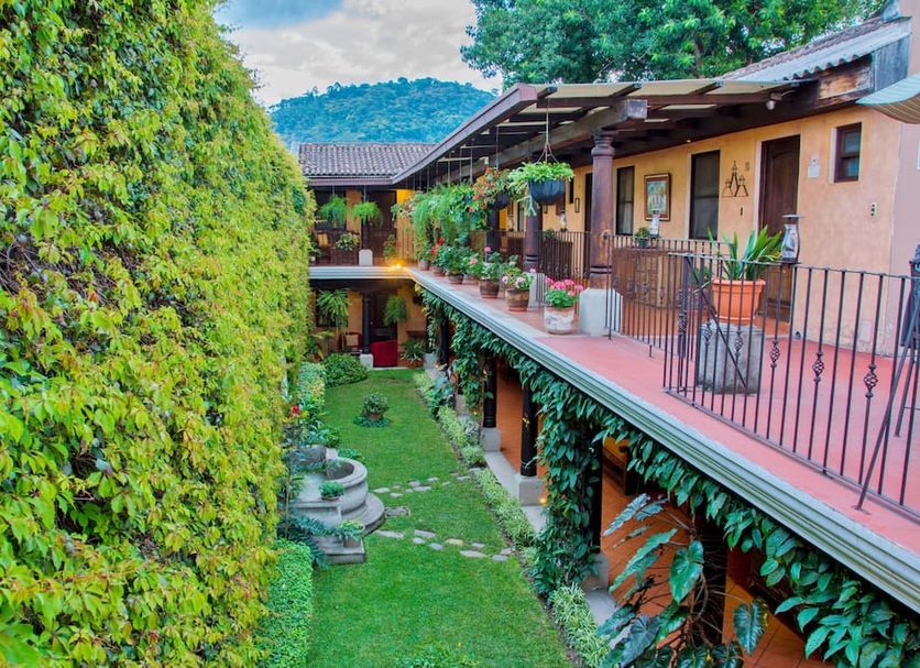 Hotel Meson del Valle by AHS in Antigua, lush courtyard with balconies and mountain view