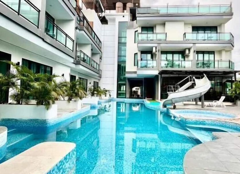 Chalay Monta in Hua Hin with a pool, slide, and modern hotel buildings