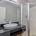 Motel 6 Santa Rosa NM bathroom with glass-enclosed shower, vessel sink, and toilet in Santa Rosa