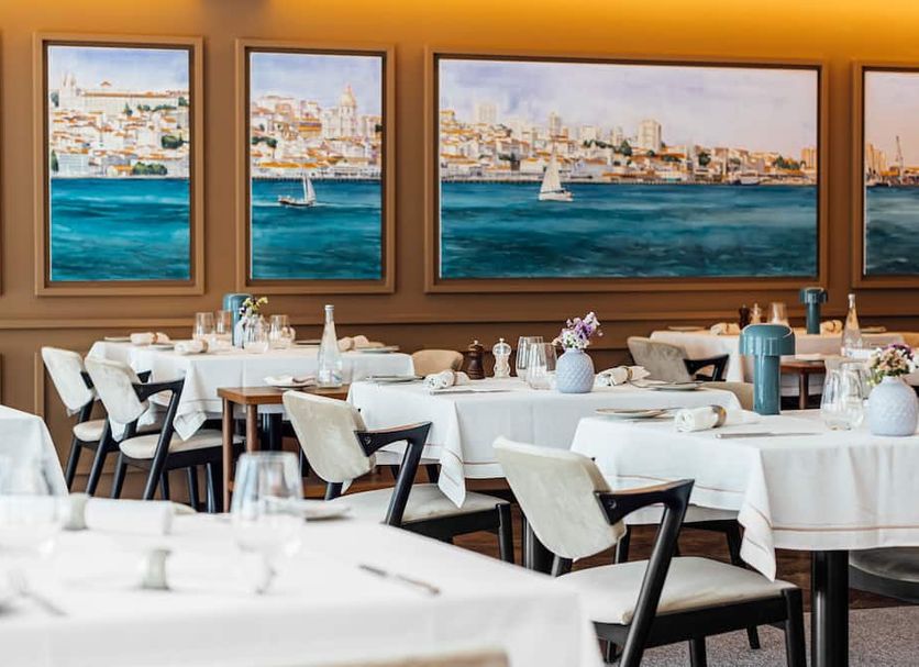 Corpo Santo Lisbon Historical Hotel dining room with tables and city-and-water views through large windows