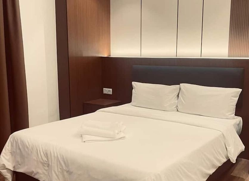 Citi Hotel Miri guest room with a neatly made bed, bedside tables, and wood-paneled headboard
