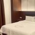 Citi Hotel Miri guest room with a neatly made bed, bedside tables, and wood-paneled headboard