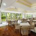 The Ubufuru Ishigaki dining room with tables, chairs, wood floors and large garden-view windows