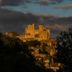 ibis Sarlat in Sarlat-la-Canéda with illuminated historic castle on a hill at dusk