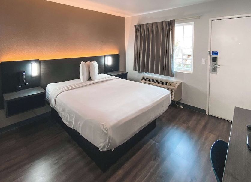 Motel 6 Sacramento West guest room with queen bed, window, desk and chair in Sacramento