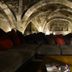 Abbaye De Maizieres in Beaune: vaulted stone lounge with sectional sofa, warm lighting and low table