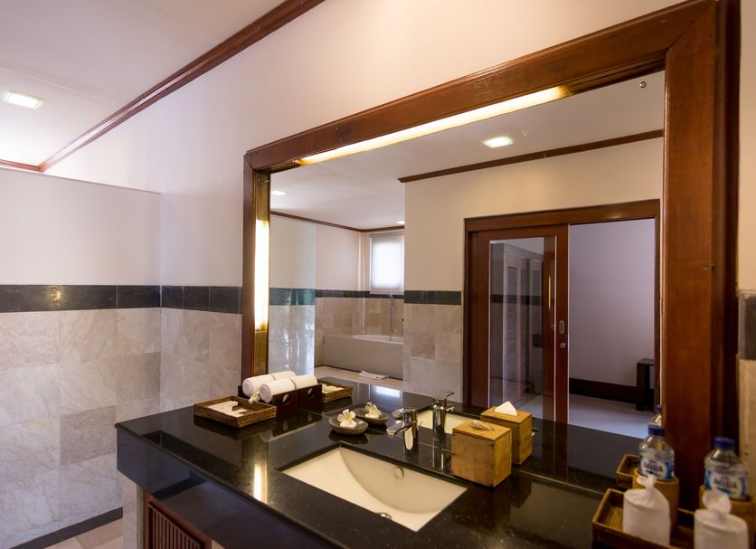 The Payogan Villa Resort and Spa Ubud bathroom with vanity, large mirror and tiled walls