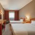 Estalagem Vianorte in Matosinhos hotel room with two twin beds, desk, wall TV and window curtains