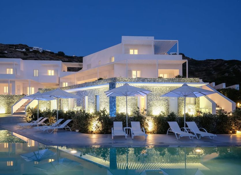 Relux Ios Hotel in Ios with illuminated poolside terraces and lounge chairs at dusk