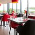 Bastion Hotel Barendrecht restaurant with red chairs and large windows in Barendrecht