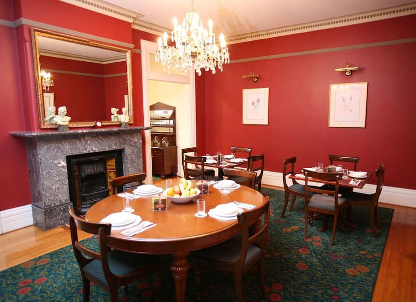 Darcys Hotel at Homebush dining room with round tables, chandelier and red walls