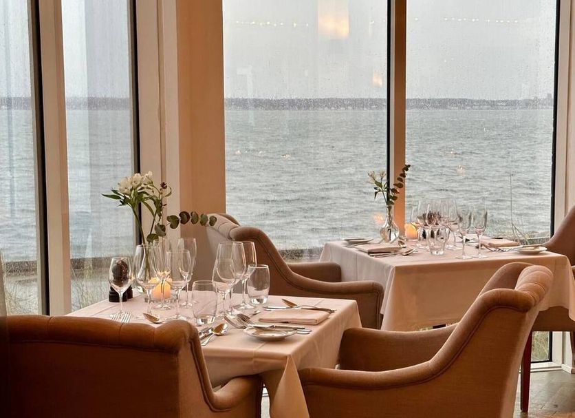Marienlyst Strandhotel in Helsingør dining room with tables by large windows overlooking the sea
