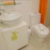 Islands Stay Hotels - Puerto Princesa bathroom with sink, toilet, shower, and orange curtain
