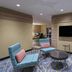 TownePlace Suites by Marriott Naples lobby seating area with wall-mounted TV and modern chairs