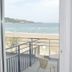 Hôtel Valencia in Hendaye: balcony view of beach, sea, and railing with flowers inside.