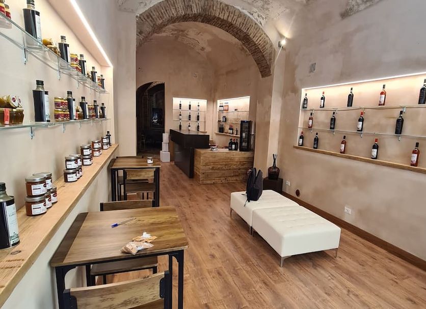 Allegra Toscana - Affittacamere Guest house in Arezzo, bottle-lined bar area with rustic arch and seating