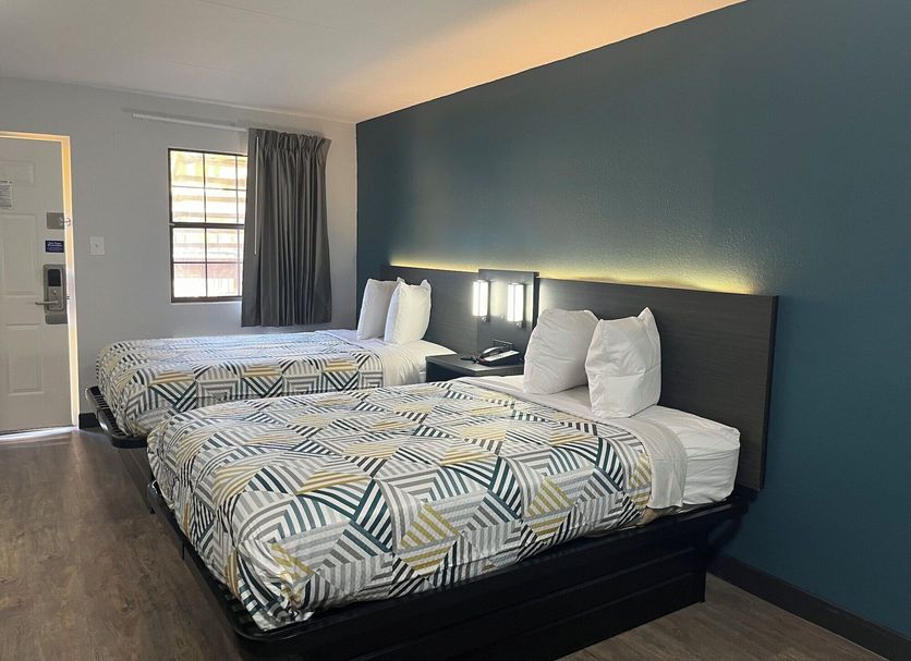 Studio 6 Huntsville hotel room with two double beds, dark accent wall and window in Huntsville