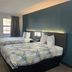 Studio 6 Huntsville hotel room with two double beds, dark accent wall and window in Huntsville