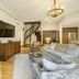 The Osprey at Beaver Creek, A RockResort living room with stone fireplace, sectional sofa and spiral stairs