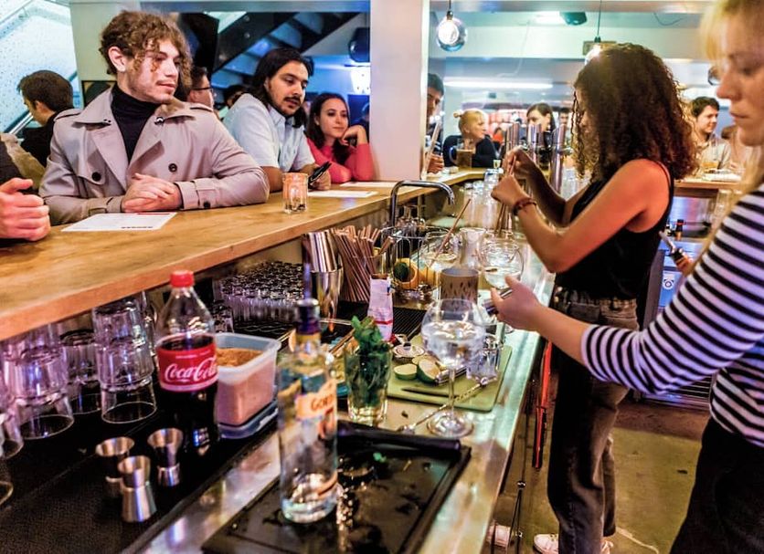 Wombat's City Hostel Vienna Naschmarkt bar with guests mingling and drinks at the counter in Vienna