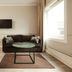 Roros Hotel in Røros guest room with sofa, desk, wall-mounted TV and large window