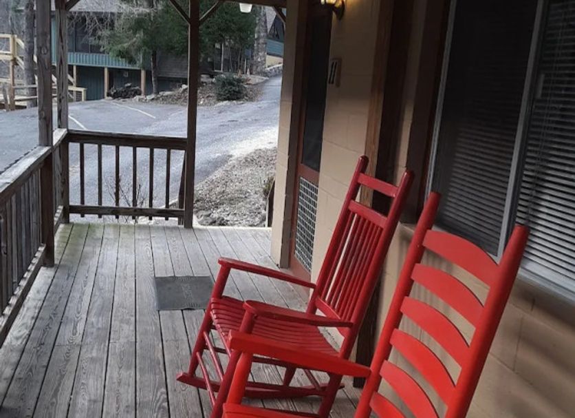 Evening Shade River Lodge & Cabins porch with red rocking chairs in Chimney Rock