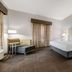 Best Western Auburndale Inn & Suites guest room with king bed, seating area, and window curtains