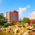 Jinan Jier Hotel in Jinan with a red high-rise, landscaped gardens, and waterfall pond