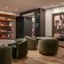 Four Points by Sheraton Los Angeles Westside lobby seating area with round tables and wood shelving