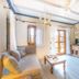 Abeliona Retreat in Ambelióna stone-walled living room with sofa, coffee table, TV and wooden dining table