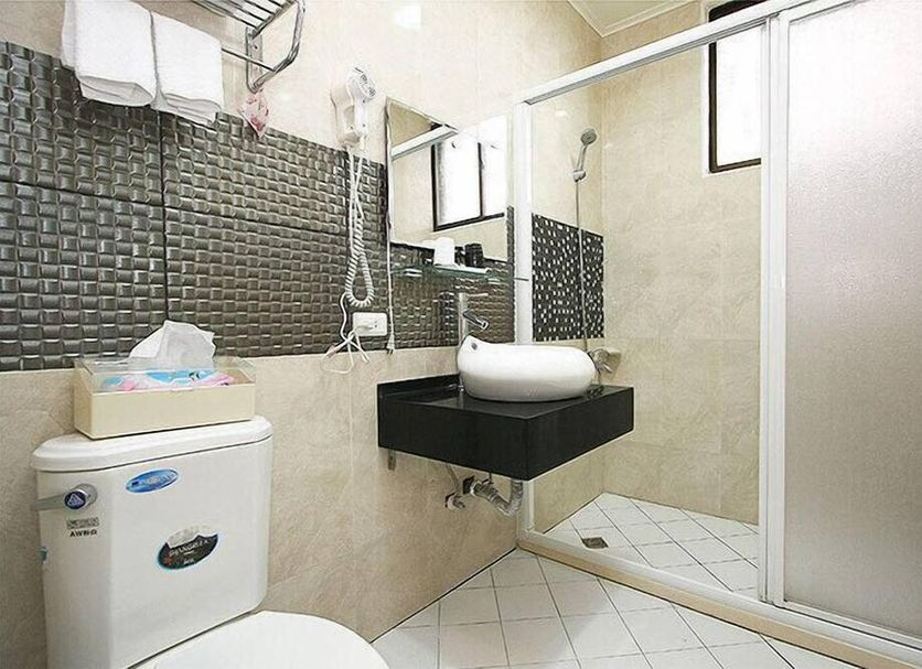 Hualien Dawan B&B in Hualien City bathroom with sink, toilet, shower, and sliding glass shower door