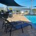 Airlie Apartments in Airlie Beach with a shaded outdoor pool and lounge chairs overlooking the water
