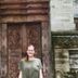The Packer Lodge Yogyakarta in Yogyakarta with a guest standing before an ornate carved doorway