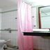 Hotel Casa di William bathroom with toilet, pink shower curtain and sink in Khajurāho