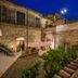 Tenuta Ciminata Greco in Rossano, stone courtyard with outdoor seating and terrace at dusk