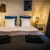 Arctic Gourmet Cabin in Kiruna: cozy double bed with bedside lamps and wall art