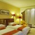 Gold River Side Hotel, Jiaxing guest room with two twin beds, armchair, and large curtained window