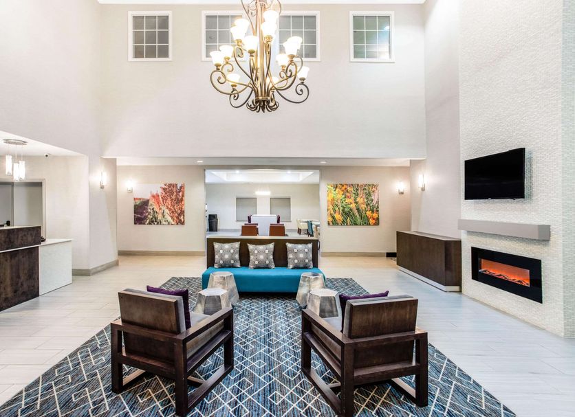 La Quinta Inn & Suites by Wyndham Hillsboro lobby with chandelier, seating area, and modern fireplace