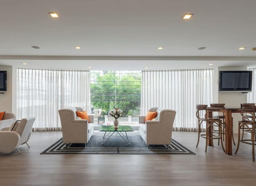 Beverly 33 by Aspira in Bangkok lounge with sofas, coffee table, bar stools, and large windows