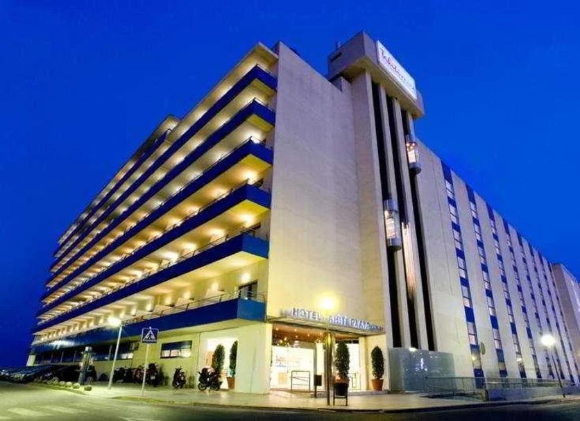 Tahití Playa Suites in Santa Susanna, modern hotel exterior at dusk with illuminated balconies