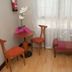 Hotel La Ronda in Castro-Urdiales with two chairs, small table, orchid, and pink upholstered bench by a window