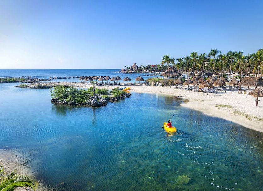 Catalonia Yucatan Beach, Puerto Aventuras: lagoon pool beside a sandy beach and palm trees