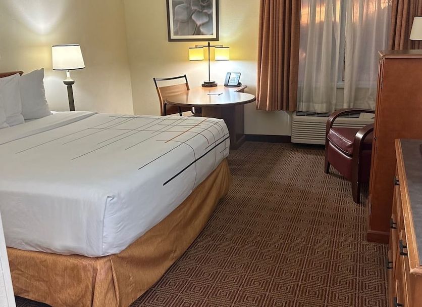 La Quinta Inn & Suites by Wyndham Sawgrass in Sunrise guest room with king bed, desk, and window seating