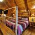 A Cabin In The Woods in Pigeon Forge bedroom with log walls, quilted bed, wood railing, and bathrobes