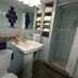Lariat Motel, Hardin: compact bathroom with pedestal sink, toilet, tiled shower, and towel shelves