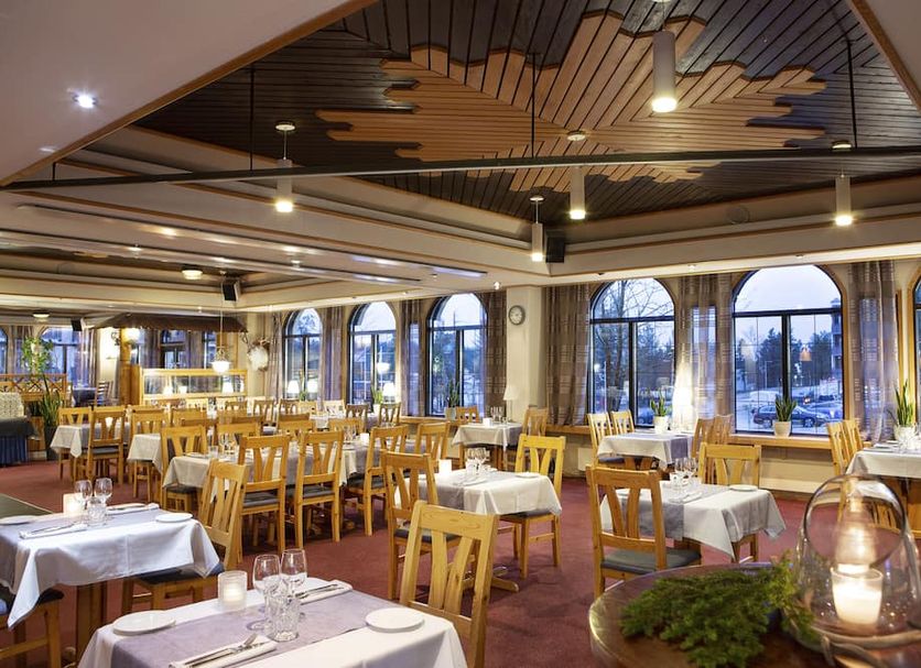 Lapland Hotels Riekonlinna in Saariselka dining room with large arched windows and set tables