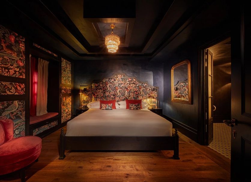 Palma Riad in Palma de Mallorca, five-star room with ornate floral headboard and dark dramatic decor